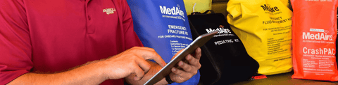 Yacht crew using a tablet to access MediTrack, and medical kits visible in the background