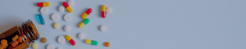 Assorted pills and capsules beside an open medicine bottle
