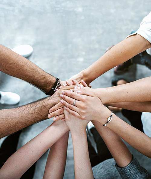 People placing their hands together in a collaborative gesture