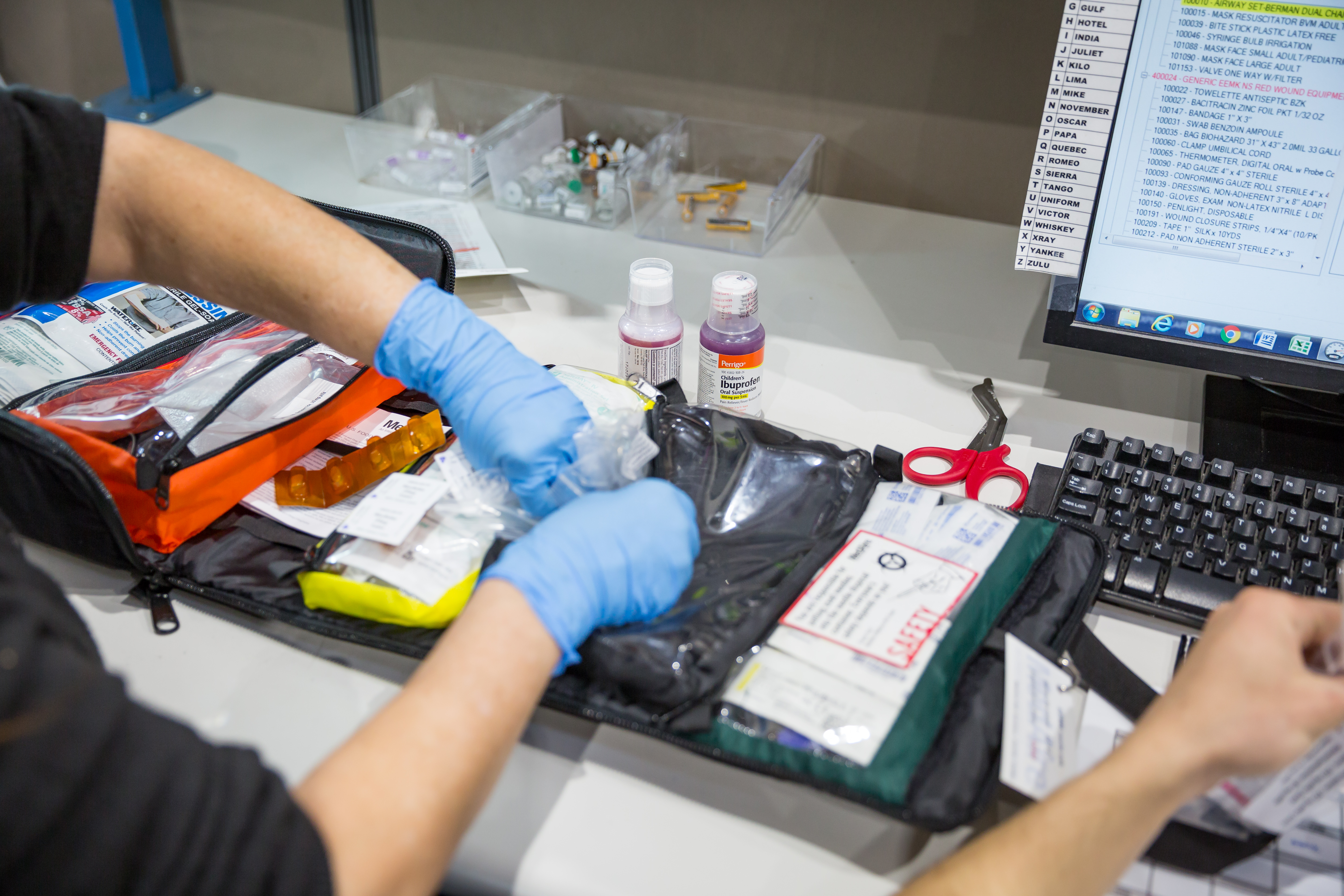 person_wearing_gloves_and_packing_first_aid_kit